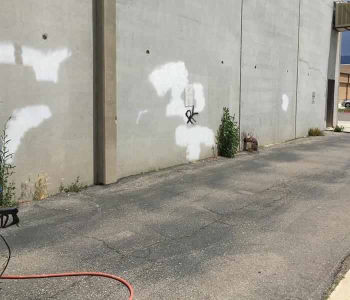 Concrete wall covered in graffiti.